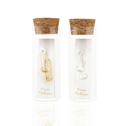 Gold and silver safety pin hoops scattered on a blue background