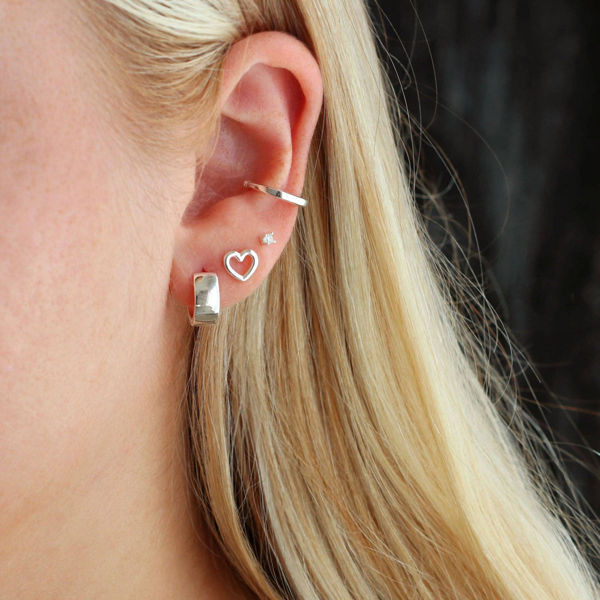 Silver-tone heart outline studs laid on linen